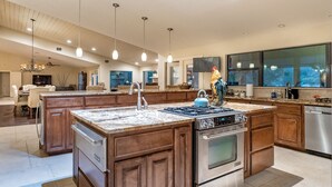 A spacious kitchen with a large island, stainless steel appliances, and a modern design.