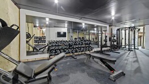 Ett gym med löpband, träningsbänkar och fria vikter.
