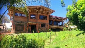A two-story house with a balcony, surrounded by greenery. - Bird Cabin (Antioquia)