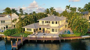 A waterfront property with a large deck, a pool, and a boat dock.