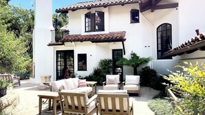 A two-story house with a patio area featuring outdoor furniture, including sofas and chairs. - Montecito - Ocean and Mountain Views - Total Renovation Completed! (Montecito)