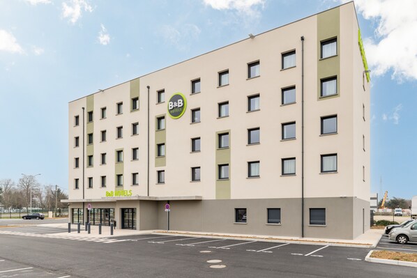 Ein Bed and Breakfast Hotel mit modernem Design, mehreren Etagen und einem Parkplatz vor dem Gebäude.