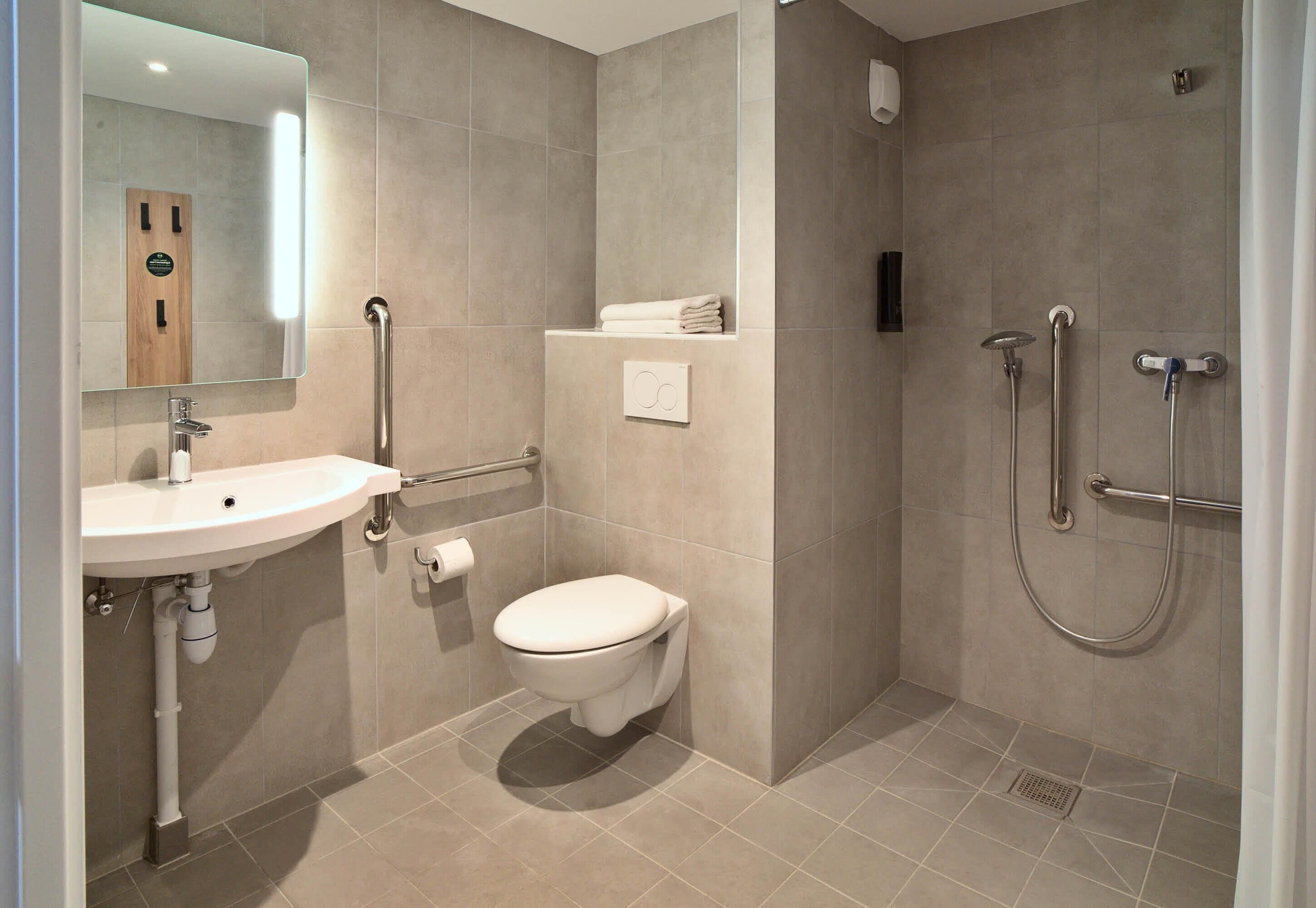 A modern bathroom with a sink, toilet, and shower.