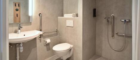 Un baño moderno con lavamanos, inodoro y ducha.