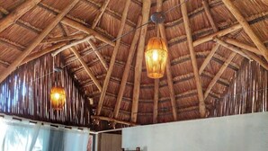 A bedroom with a large bed, wooden ceiling beams, and two hanging light fixtures. -  PB-C1 Habitacion tipo Cabaña Segundo Piso (Cartagena)