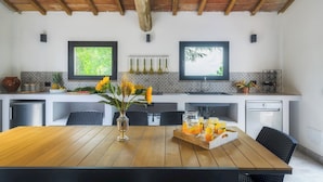 A modern kitchen with a wooden table, two windows, and a tiled backsplash. - Fonte Pinella 8, Emma Villas (Chiusi)