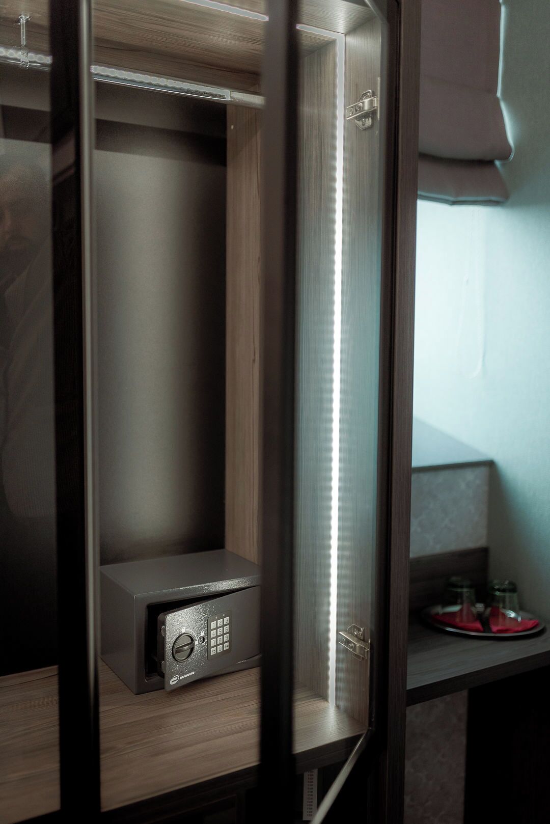 Un baño moderno y compacto, con cabina de cristal, lavabo integrado y grifo a la vista.