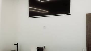 Un baño moderno con un mueble de tocador oscuro, un lavabo negro y un espejo grande.
