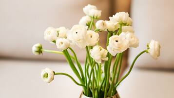 A vase with white flowers on a table.
