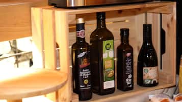A wooden cabinet with bottles of olive oil and other condiments.