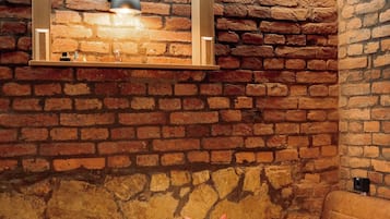Un comedor acogedor con pared de ladrillo, mesa de madera y un banco.