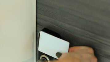Uma mão operando o mecanismo de fechadura da porta.