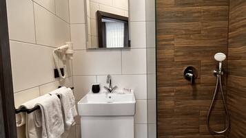 A modern bathroom with a white sink, mirror, and towel rack.