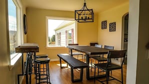 Un espace repas avec une table en bois, des bancs et des chaises.