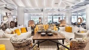 A spacious living area with white sofas, a wooden coffee table, and decorative items. - Impeccable 1-bed Cottage (St. Barthelemy)