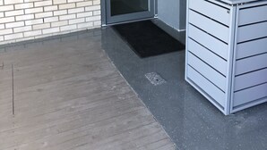 Entrada d'un apartament modern amb una porta de vidre, una bústia i un armari metàl·lic.