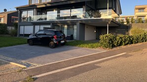 Una casa moderna de dos pisos amb un cotxe al vial.