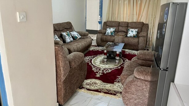 Ein Wohnzimmer mit zwei Sofas, einem Couchtisch und einem Kühlschrank.