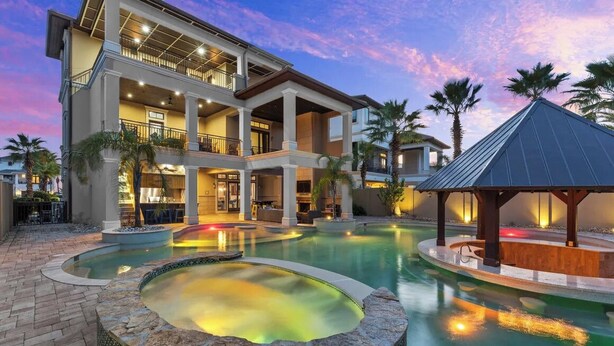 A multi-story hotel with a pool area, including a hot tub and a covered seating area. - Splash — Largest Private Resort-Style Pool in Destin (Destin)