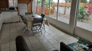 Une cuisine équipée d’une table à manger, de chaises, d’un réfrigérateur et d’un four à micro-ondes.