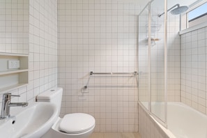 A modern bathroom with a toilet, sink, and shower.