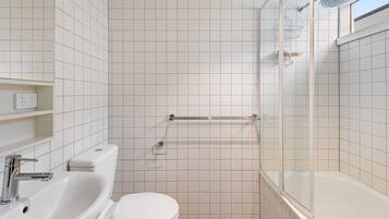 Bathtub, hair dryer, towels, shampoo