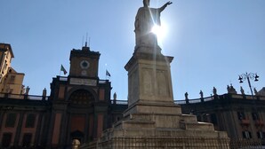 A statue with outstretched arms, a clock tower, and a flag in the background. - Five Boutique Rooms - Camera 1 (Naples)
