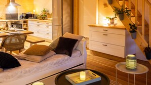 A cozy living room with a sofa, coffee table, and a staircase leading to an upper level. - Graine de Bonheur gite ambiance chalet 7 persons (Chille)