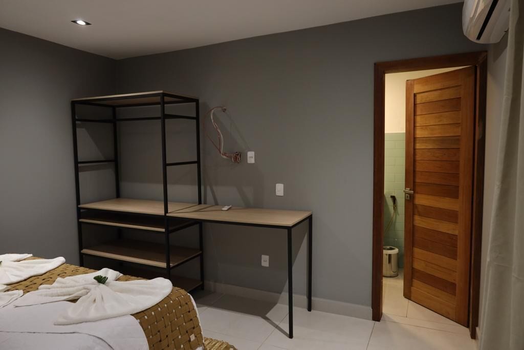A bedroom with a bunk bed, a desk, and a chair. There is a door leading to another room.
