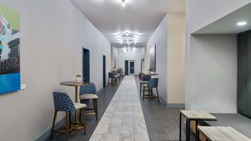 Un couloir moderne avec des coins salon, un long couloir et une porte au bout.