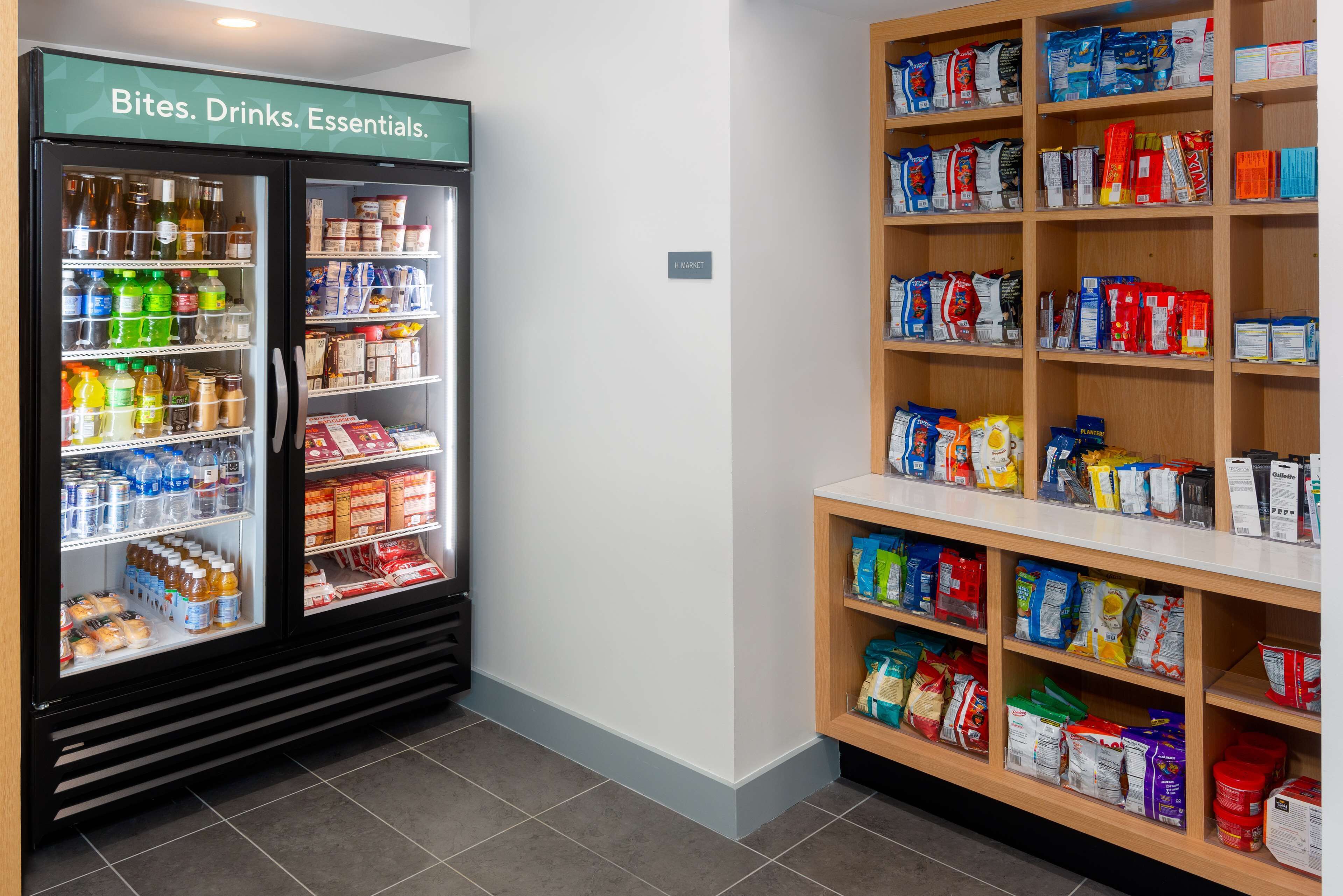 Una sección refrigerada con bebidas y aperitivos, y estantes contiguos con diversos productos envasados.