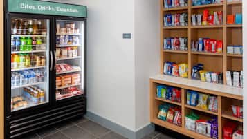 Una sección refrigerada con bebidas y aperitivos, y estantes contiguos con diversos productos envasados.