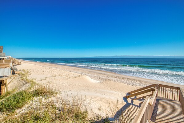 Enjoy a serene beachfront setting with a boardwalk leading to the expansive sandy beach.