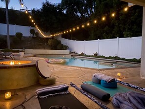 A backyard with a swimming pool, a fire pit, and string lights. - Retreat style private pool home in Mission Viejo (Mission Viejo)