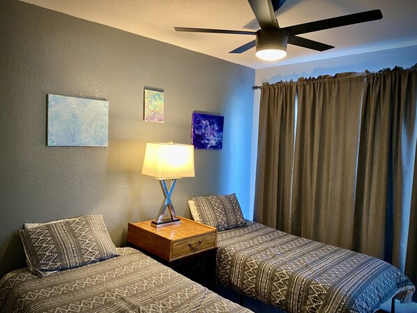 A hotel room with two beds, a ceiling fan, a nightstand with a lamp, and a window with curtains. - Retreat style private pool home in Mission Viejo (Mission Viejo)