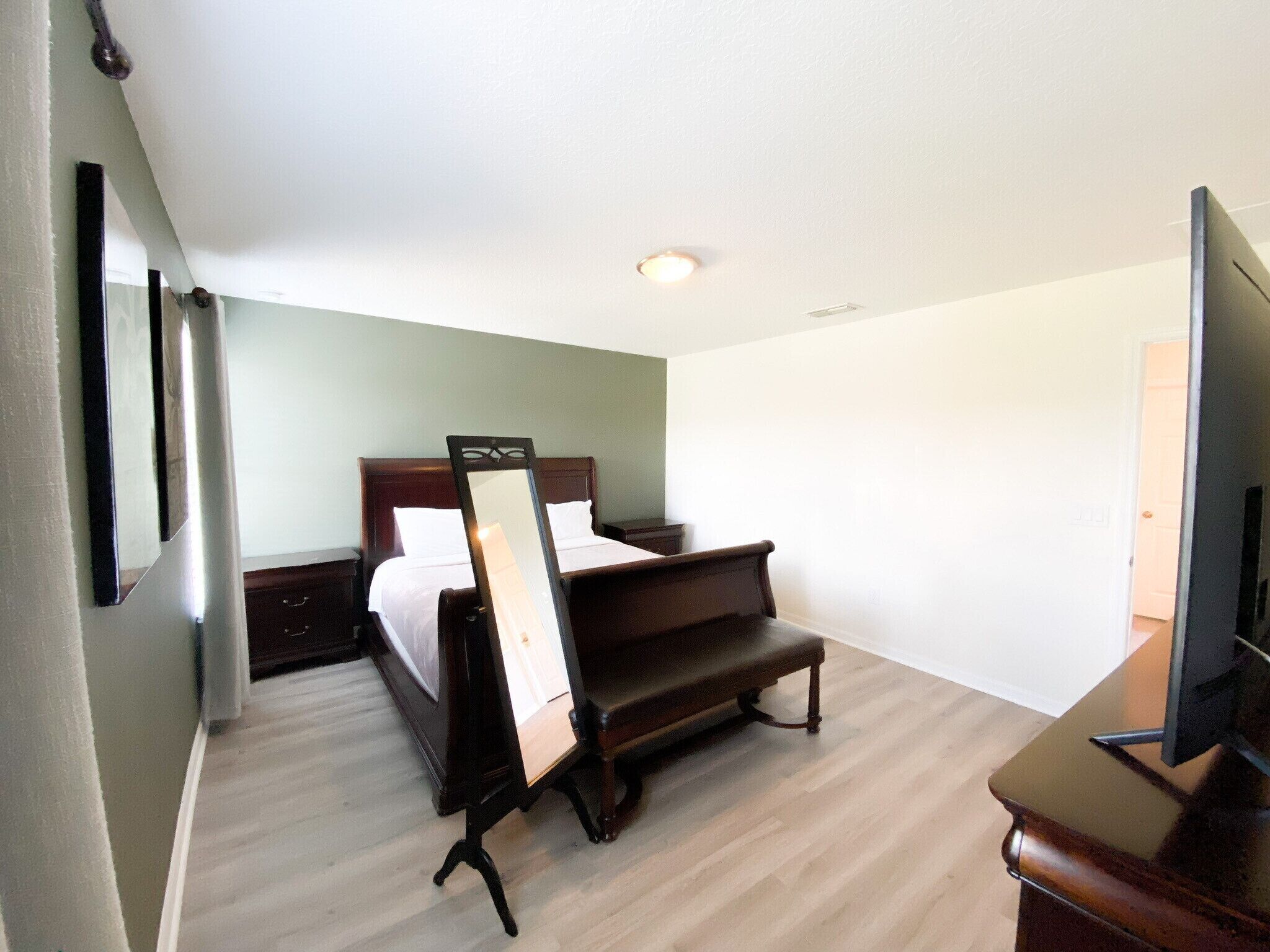 Een hotelkamer met een bed, een bureau, een stoel en een televisietoestel.