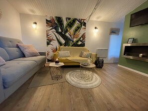 Een moderne woonkamer met een bank, een bijzettafeltje en een decoratief wandobject.
