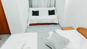 A hotel room with a bed, a chair, and a table with towels and a bottle. - Apartments Dragobratović - One Bedroom Apartment with Balcony and Sea View (Apartment 3) (Klek)