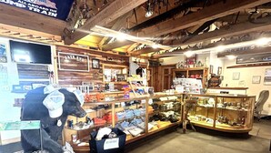 A rustic shop with wooden shelves displaying various items, a sign for 'Days End' on the wall, and a 'Garden Flag Stand' sign. - Blackhills Cabin 2 Twin Beds in Sturgis, SD.Close to Downtown, Deadwood, Spearfish and Mt. Rushmore (Sturgis)
