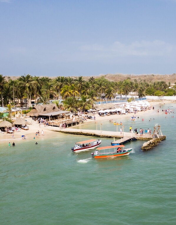 A beach with boats, palm trees, and a pier. - PB-C2 HABITACION TIPO CABAÑA EN 2 PISO (Cartagena)