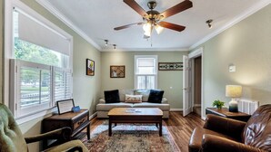 A living room with a ceiling fan, a sofa, a coffee table, and a chair. - Dog-Friendly Norfolk Cottage Near Ocean View Beach (Norfolk)