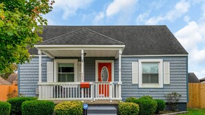 A two-story house with a front porch, a red door, and a mailbox. - Dog-Friendly Norfolk Cottage Near Ocean View Beach (Norfolk)