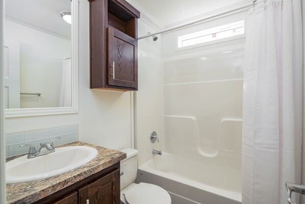Une salle de bain avec un lavabo, des toilettes et une baignoire.
