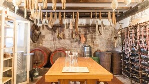 A rustic cellar with wooden beams, hanging meat, and wine barrels. - Villa Eufemia - Country farmhouse with pool (Piano)