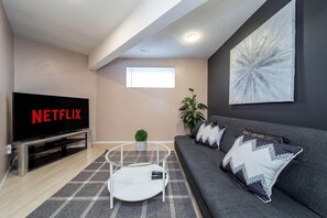 Relax in style with a flat-screen TV, comfortable sofa, and a touch of greenery.