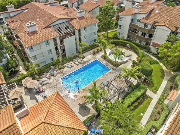 A residential area with a swimming pool surrounded by lush greenery and a well-maintained garden.