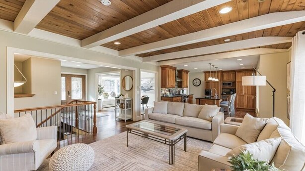 A spacious living room with a wooden ceiling, a sofa, a coffee table, and a staircase leading to another level. - Heavenly Home/Minnetonka Lakes/Nature Scenic View (Minnetonka)