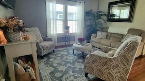 A living room with a ceiling fan, a sofa, a chair, a coffee table, and a rug. - Clean and cozy 3 bdrm one bath home in the heart of Rupert.  (Rupert)