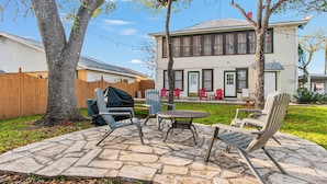 A backyard with a stone patio, outdoor furniture, and a barbecue grill. - Carriage Utopia 4 | Pet-Friendly Stay in Bandera (Bandera)