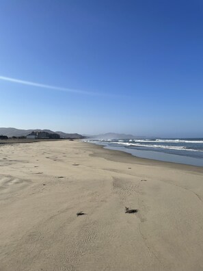 Una playa cerca, arena blanca, sillas reclinables de playa, sombrillas